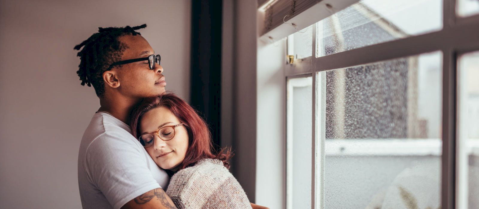 couple embracing by a window representing couples immersion therapy in duncan bc