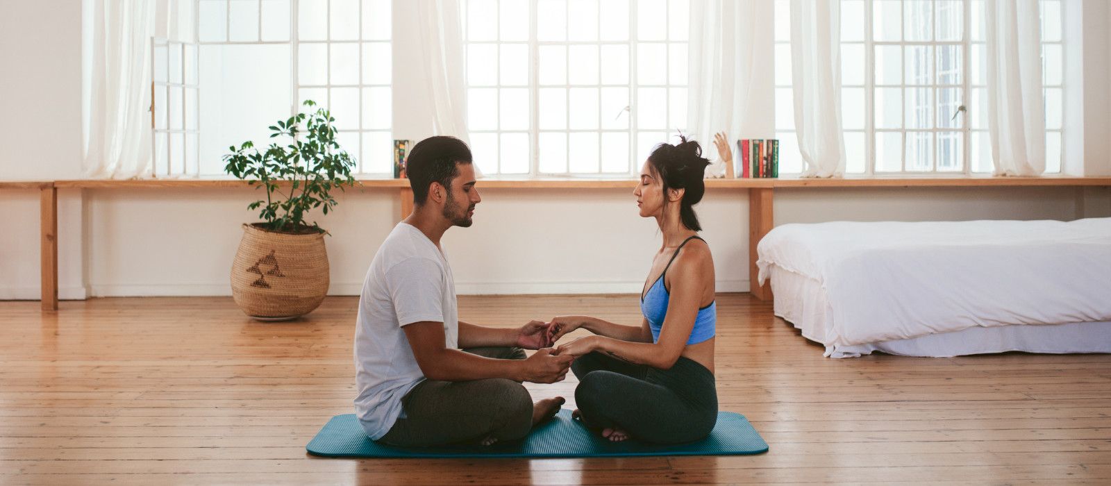 Couple sitting face to face on yoga mats during psychedelic assisted couples therapy session, healing focused counselling by Trevor Warren in Duncan BC